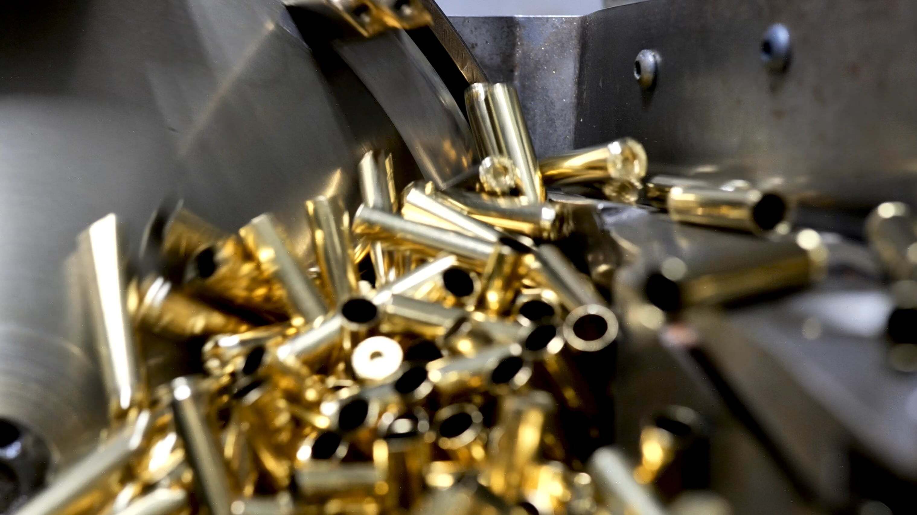 Precision-machined brass cartridge cases standing in formation